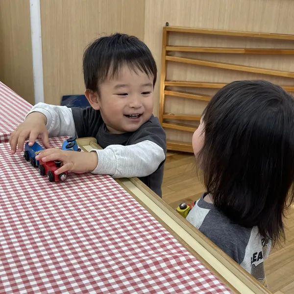 おもちゃの車で遊ぶ子ども(はっとこども園)